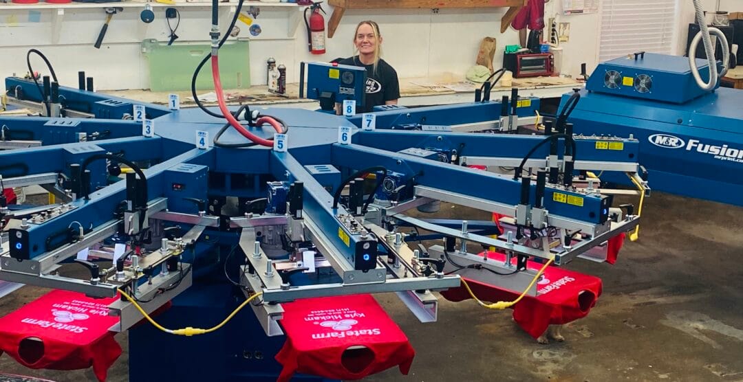 Pictured here are red custom screen printed t-shirts rolling off the press for Kyle Hickam State Farm Agent in Joplin, MO.